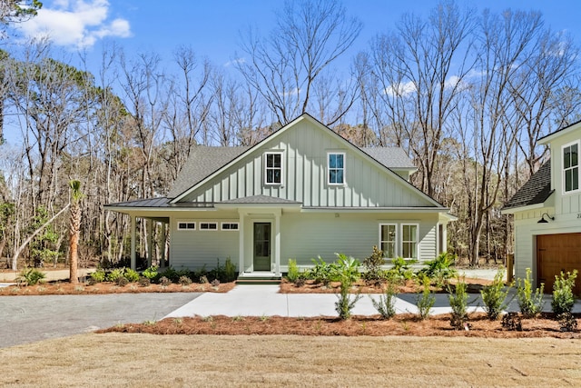 view of front of house with a garage, roof with shingles, and board and batten siding