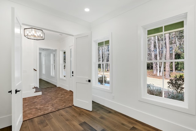 entryway with recessed lighting, baseboards, ornamental molding, dark wood-style floors, and an inviting chandelier