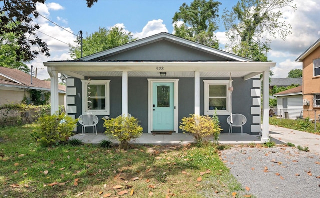 view of front of home with a porch, stucco siding, and a front lawn