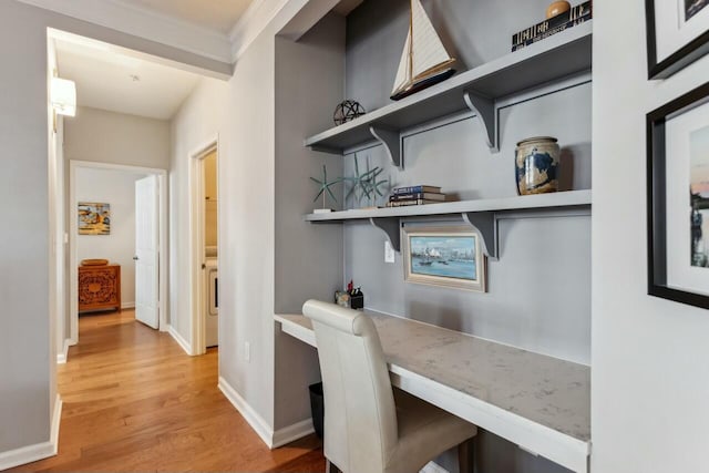 office space featuring built in study area, baseboards, and wood finished floors