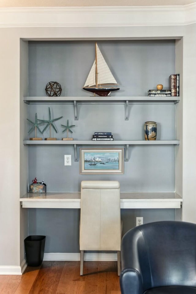 details with baseboards, built in desk, wood finished floors, and crown molding