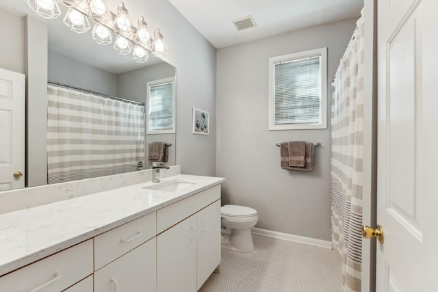 bathroom featuring toilet, visible vents, vanity, baseboards, and tile patterned floors