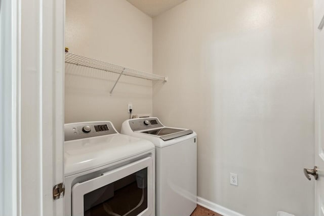 washroom with washing machine and dryer, laundry area, and baseboards