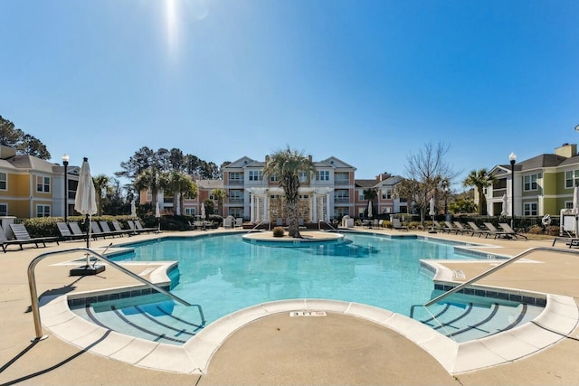 pool with a patio area and a residential view