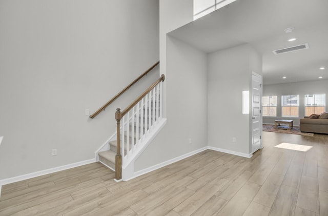 staircase featuring recessed lighting, visible vents, baseboards, and wood finished floors