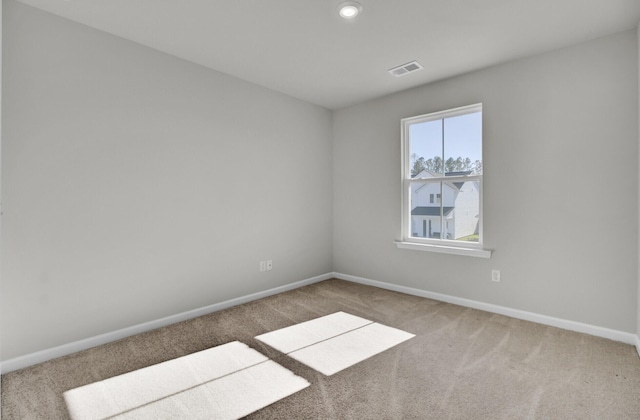 empty room featuring carpet floors, recessed lighting, visible vents, and baseboards