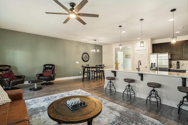 living room featuring sink, dark wood-type flooring, and ceiling fan