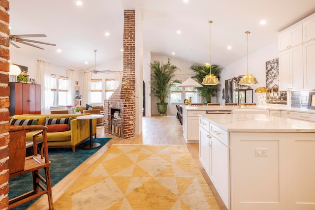 kitchen featuring plenty of natural light, white cabinets, and light hardwood / wood-style flooring