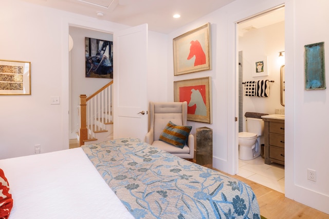 bedroom featuring light hardwood / wood-style floors and ensuite bath