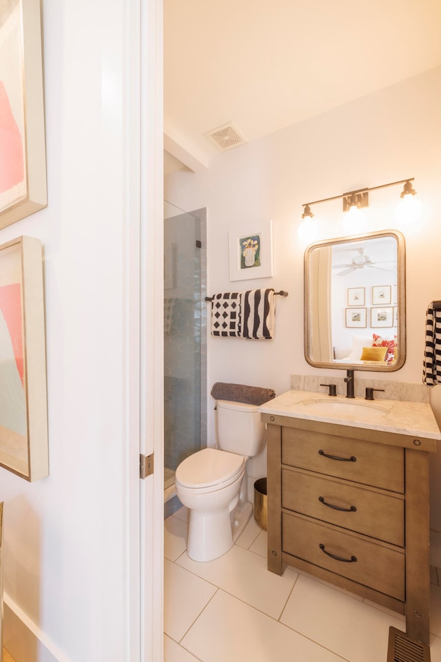 bathroom featuring tile patterned flooring, vanity, a shower with door, and toilet