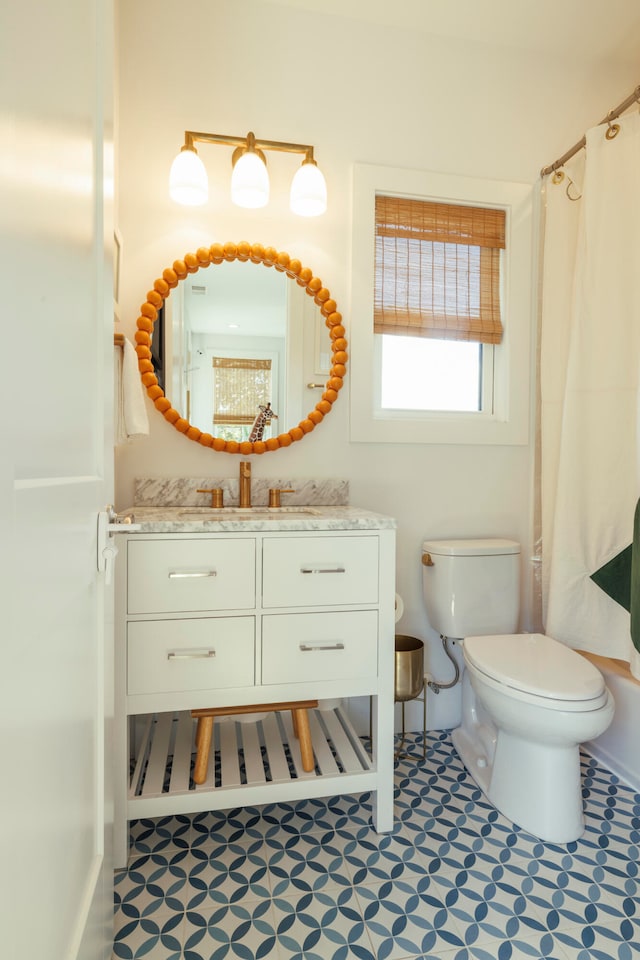 bathroom with vanity, curtained shower, and toilet