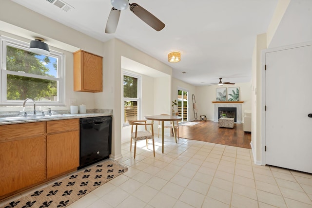 8112 Halifax Way N, Charleston, SC 29420 - kitchen featuring black dishwasher, ceiling fan, a tiled fireplace, light countertops, and light tile patterned floors