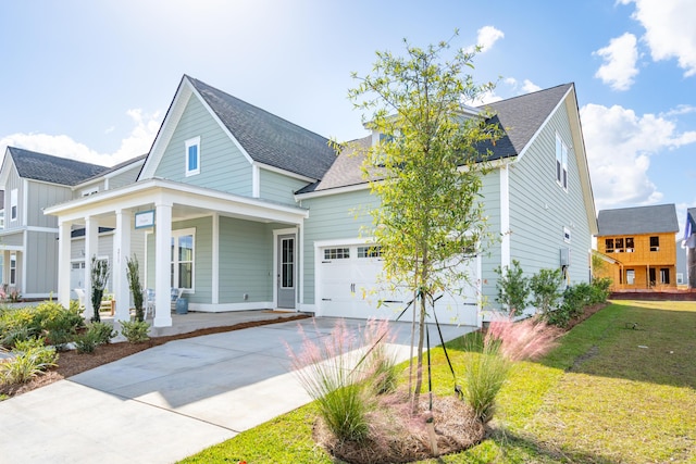 view of front of house featuring a front lawn, covered porch, and a garage