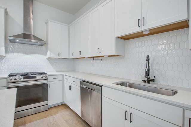 4067 S Rhett Ave, North Charleston, SC 29405 - kitchen with stainless steel appliances, wall chimney range hood, a sink, white cabinetry, and tasteful backsplash