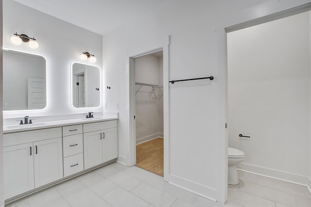 4067 S Rhett Ave, North Charleston, SC 29405 - bathroom with double vanity, a walk in closet, baseboards, and toilet