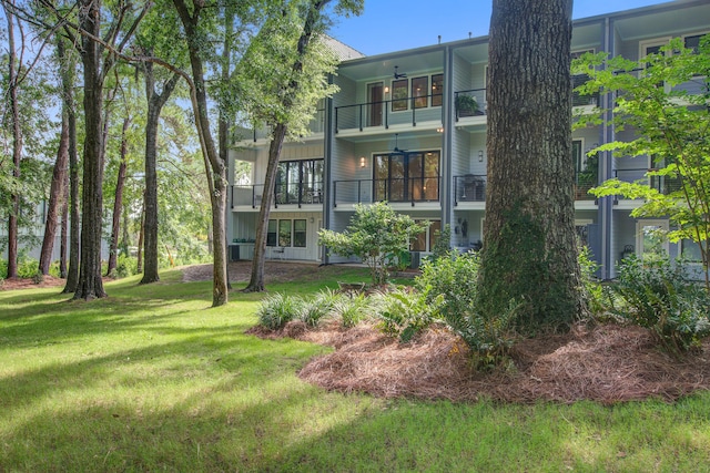 4067 S Rhett Ave, North Charleston, SC 29405 - rear view of property featuring a balcony, a lawn, and board and batten siding