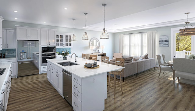 kitchen featuring dark wood-style floors, a breakfast bar area, stainless steel appliances, and a sink