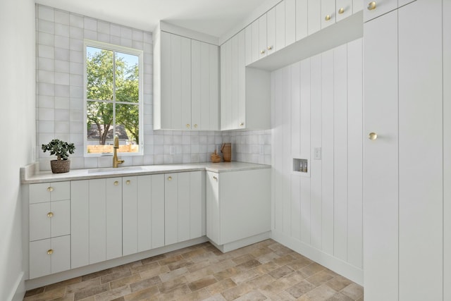 laundry area featuring cabinet space and stone finish floors
