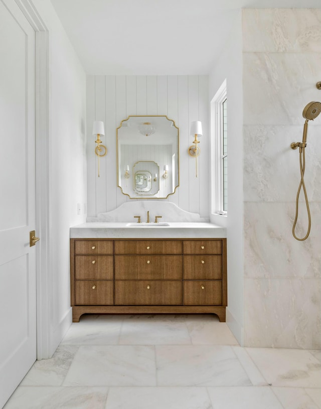bathroom with marble look tile flooring, a shower, and vanity