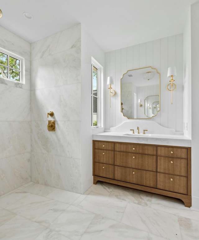 full bathroom featuring marble finish floors, vanity, and a shower
