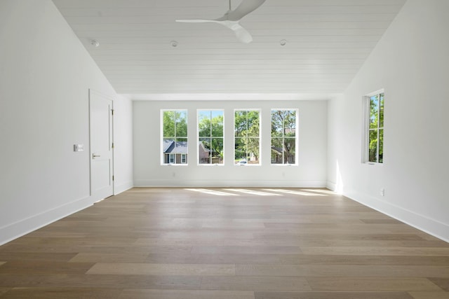spare room with healthy amount of natural light, ceiling fan, lofted ceiling, and wood finished floors