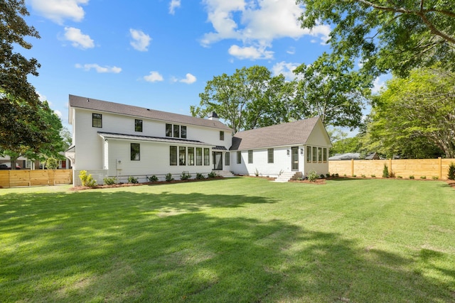 back of house featuring entry steps, a chimney, and a sunroom