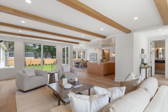 living room with light wood-style flooring, beamed ceiling, recessed lighting, a chandelier, and baseboards