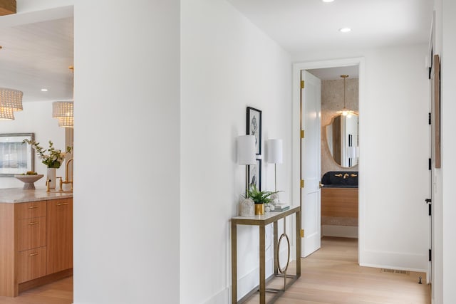 hallway with light wood-style floors, recessed lighting, and baseboards