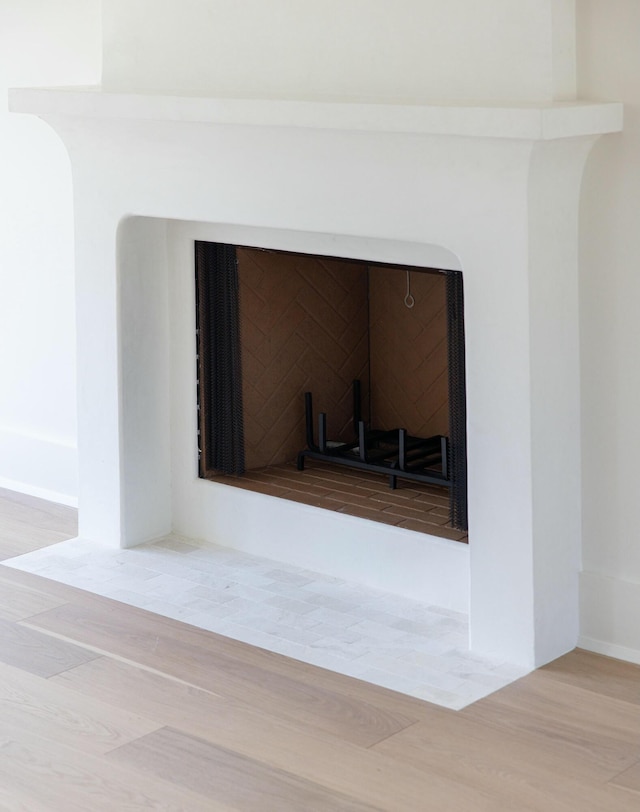 detailed view of wood finished floors and a fireplace