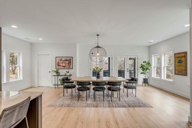 dining space featuring french doors and light wood-type flooring