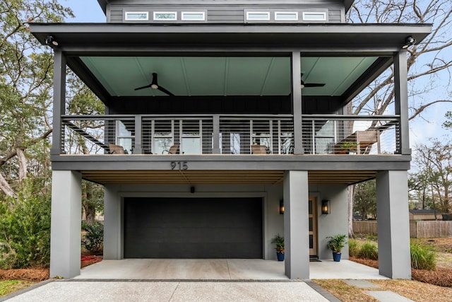 view of front of property featuring a garage, a balcony, and ceiling fan