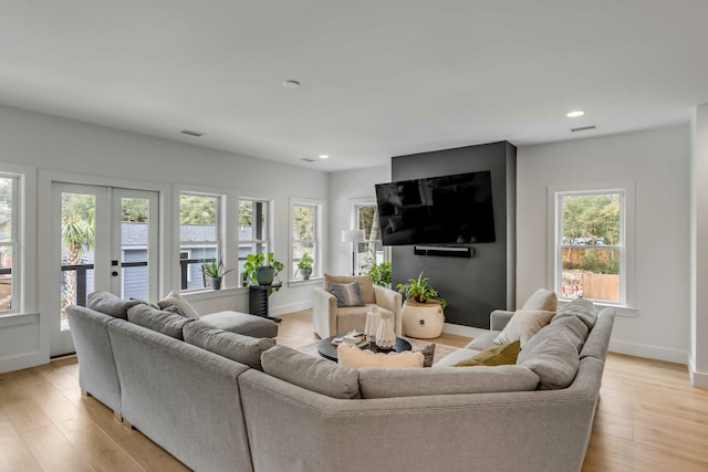 living room featuring french doors and light wood-type flooring