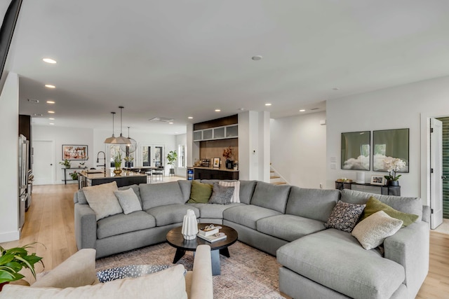 living room featuring sink and light hardwood / wood-style flooring