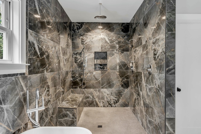 bathroom with tiled shower and tile walls