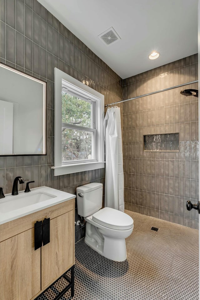 bathroom featuring tile patterned flooring, toilet, tile walls, and a shower with shower curtain