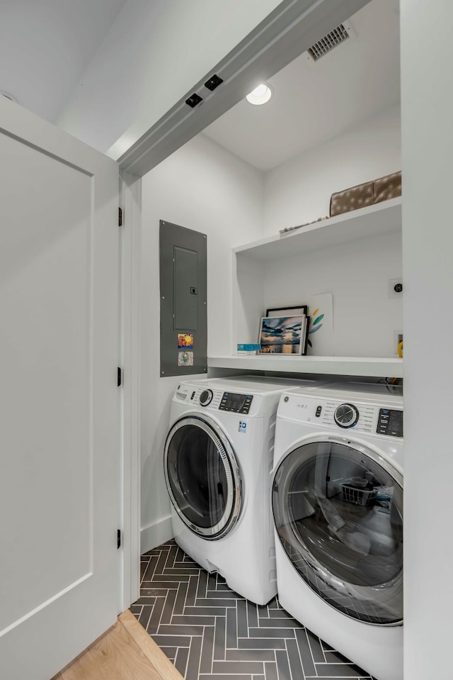 laundry room with washing machine and clothes dryer and electric panel