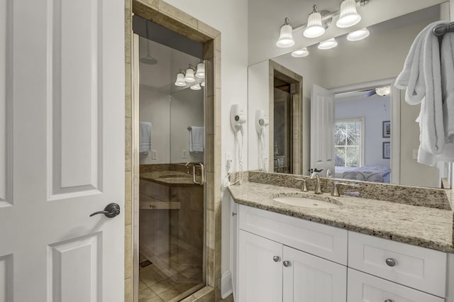 bathroom with vanity, a shower with door, and ceiling fan