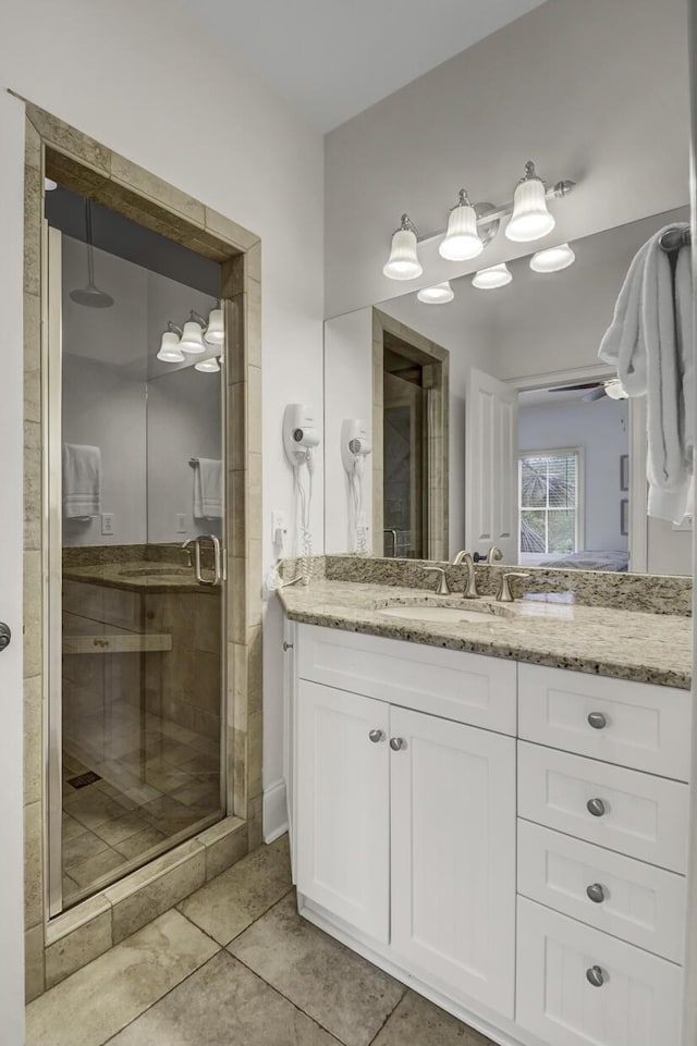 bathroom featuring an enclosed shower, vanity, tile patterned floors, and ceiling fan