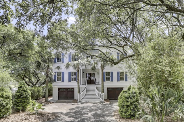 view of front of home with a porch, a garage, and a balcony