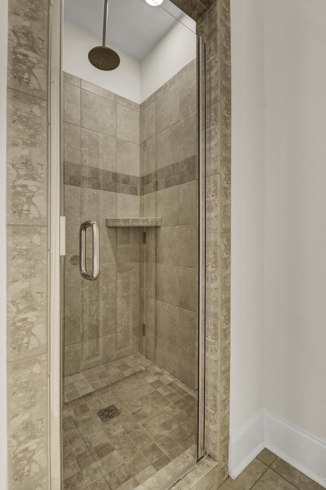 bathroom with tile patterned floors and a shower with door