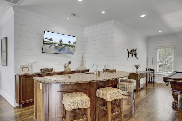 bar featuring sink, dark wood-type flooring, light stone counters, billiards, and wooden walls