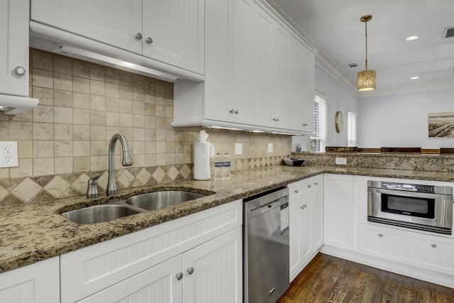 kitchen featuring decorative backsplash, appliances with stainless steel finishes, sink, white cabinets, and hanging light fixtures