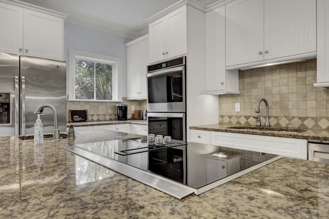 kitchen with stone counters, white cabinetry, sink, and appliances with stainless steel finishes