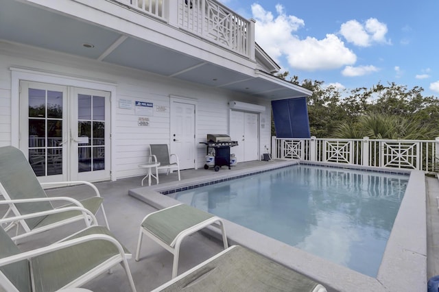 view of pool with grilling area, french doors, and a patio