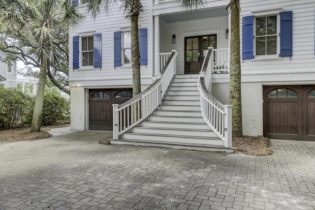 doorway to property featuring a porch and a garage