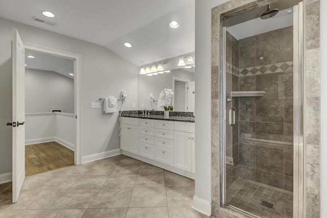 bathroom featuring tile patterned floors, a shower with door, vanity, and vaulted ceiling