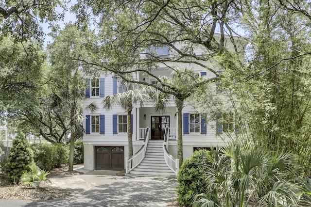 view of front facade featuring french doors, a porch, and a garage