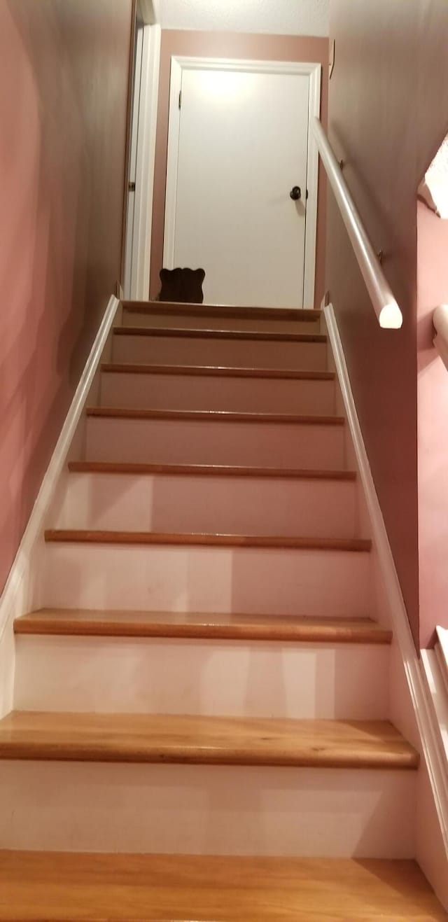 stairs featuring hardwood / wood-style flooring