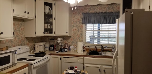 kitchen with white cabinets, white appliances, ceiling fan, and sink