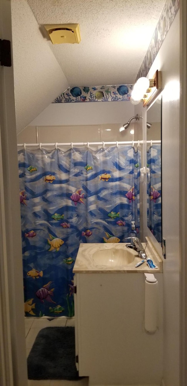 bathroom with a shower with curtain, vanity, and lofted ceiling